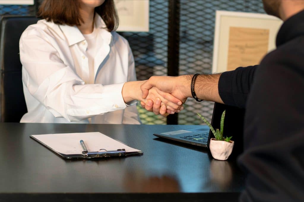 Two people shaking hands after an interview