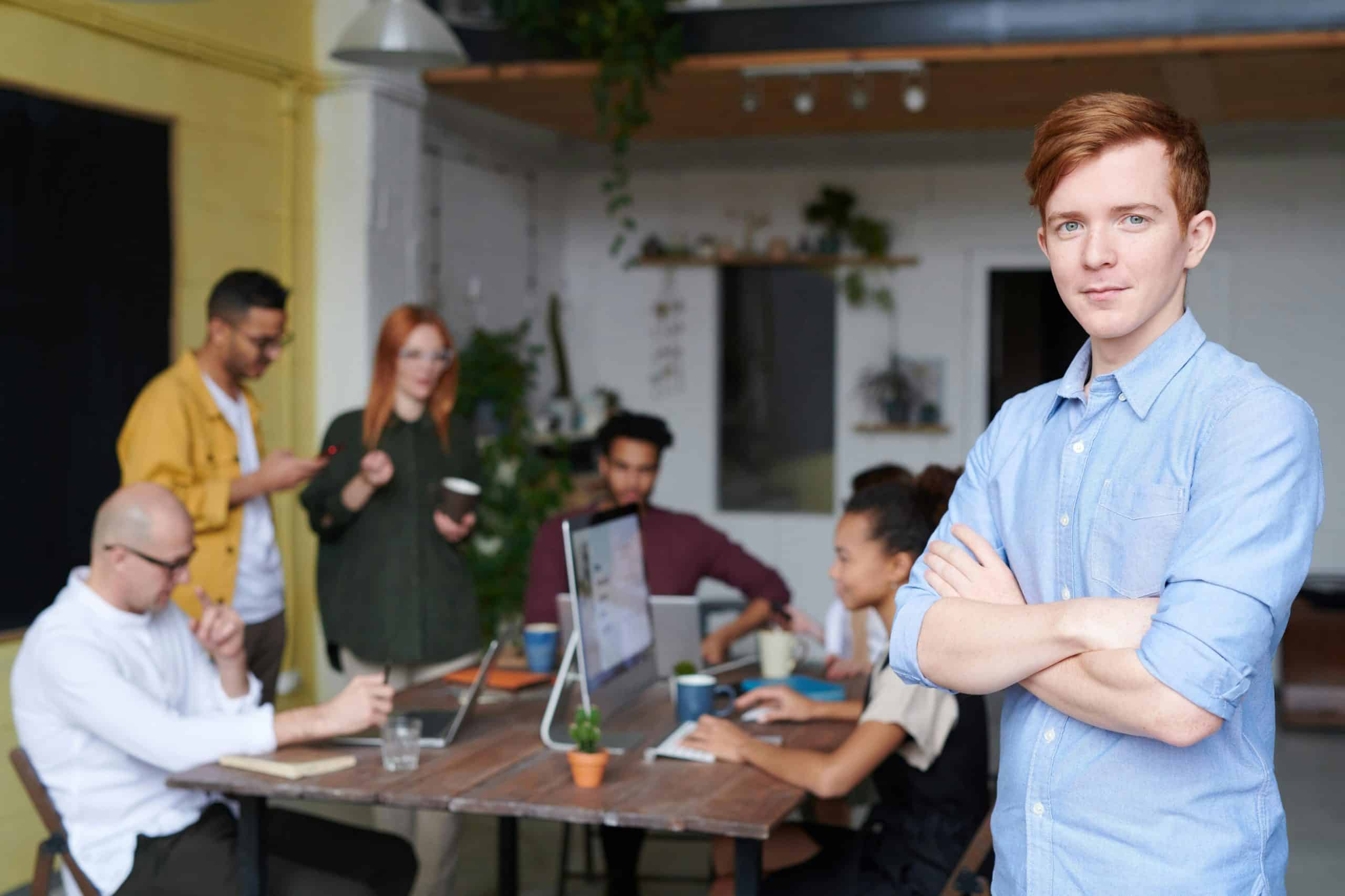 Man standing in front of office workers on computers